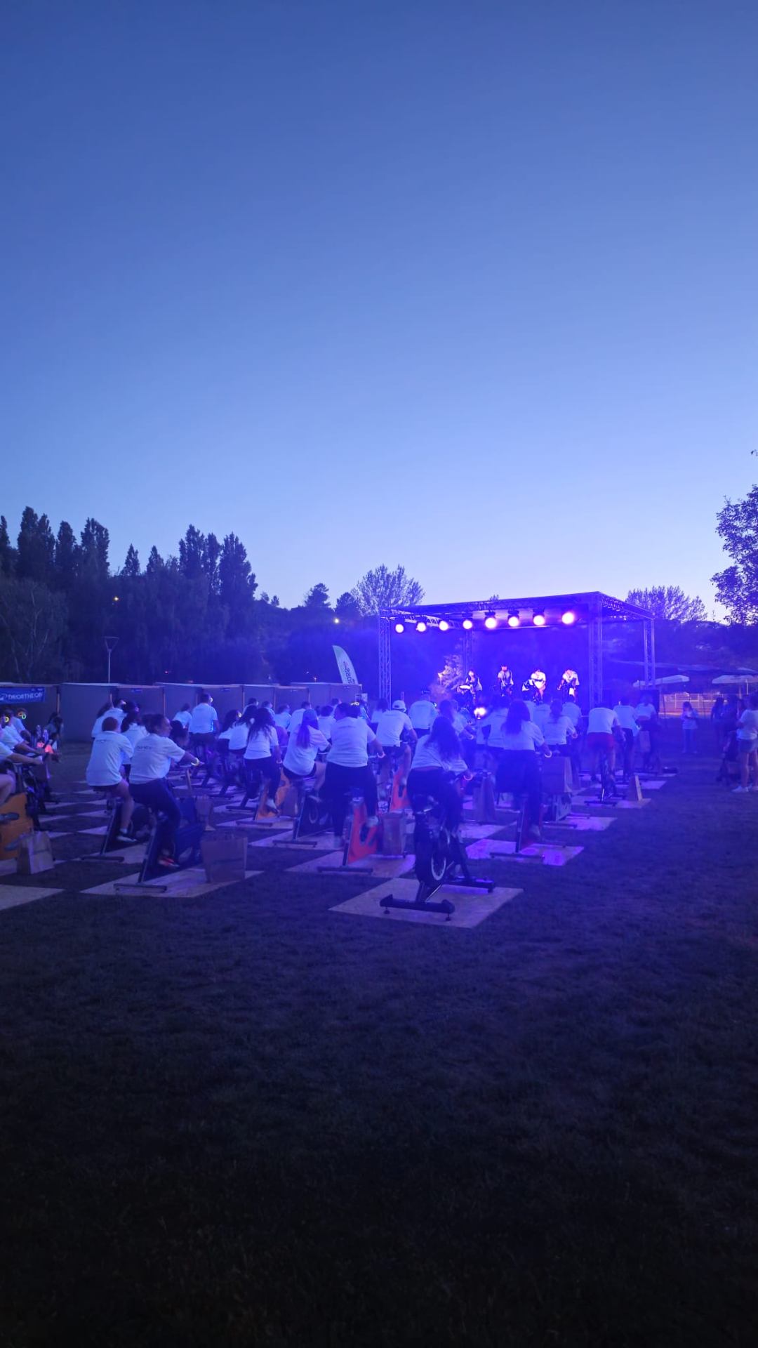 Palco iluminado durante a sessão noturna de spinning