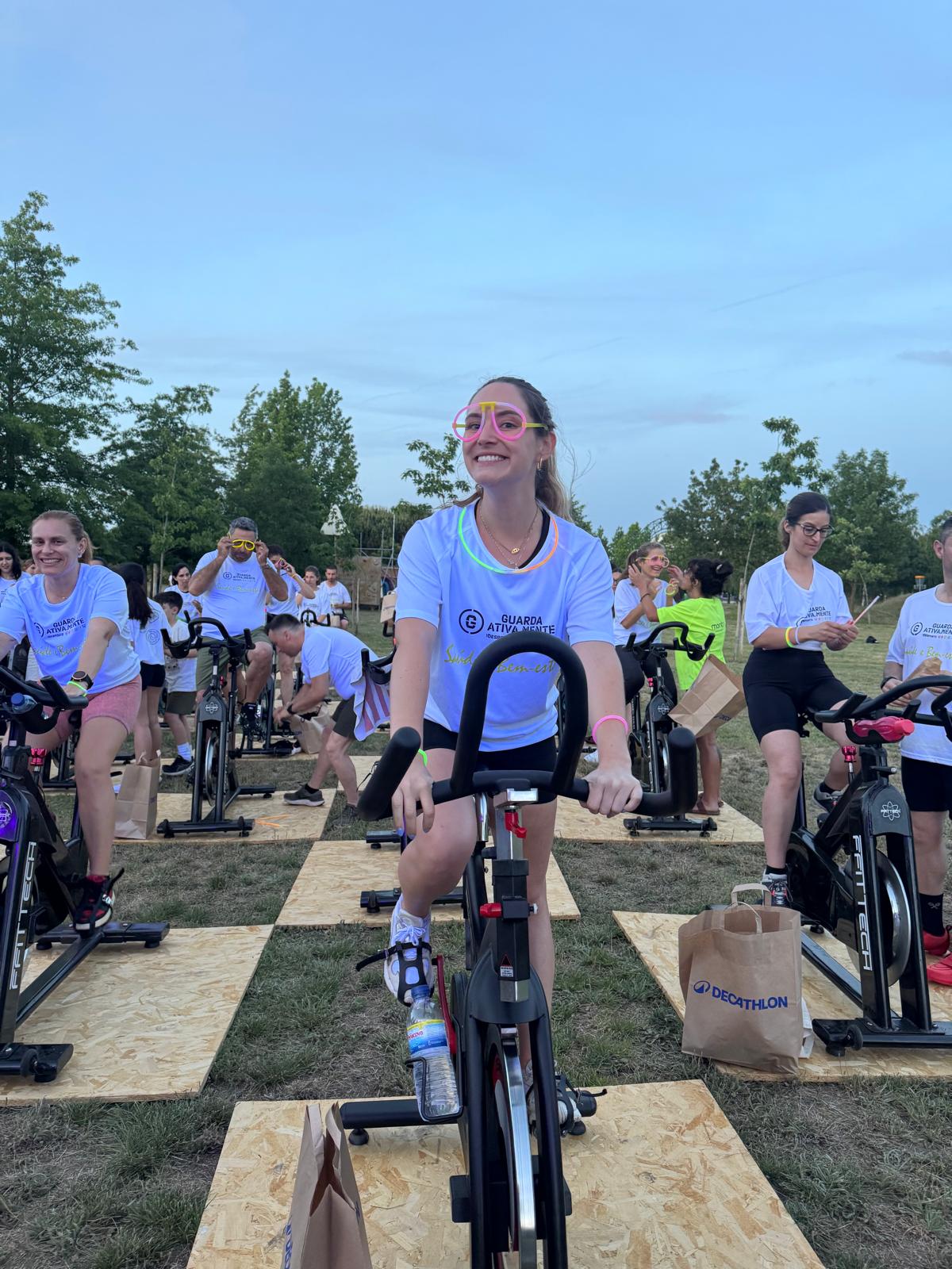 Participante na aula de spinning ao pôr-do-sol